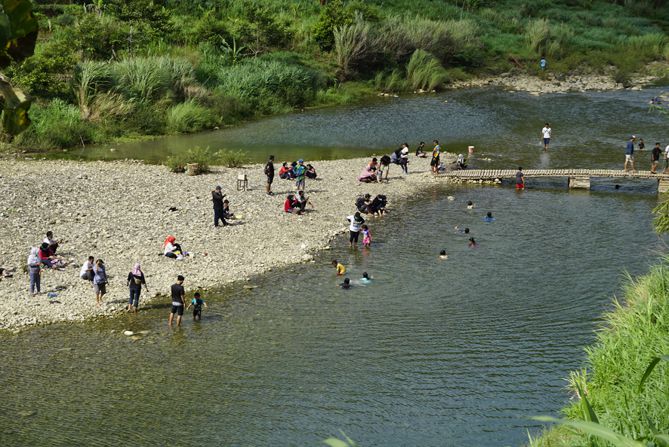 Wisatawan bermain di sepanjang aliran Sungai Oya