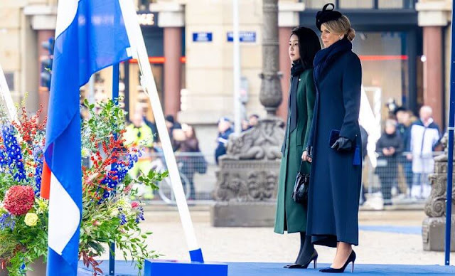 Queen Maxima wore a navy blue wool coat and, blue silk dress by Natan. Kim Keon Hee wore a green wool coat by Max Mara