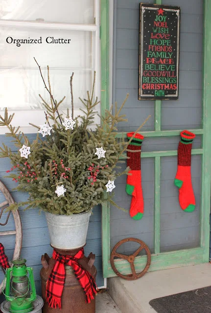 Photo of a screen door and other junk on a Christmas covered patio.