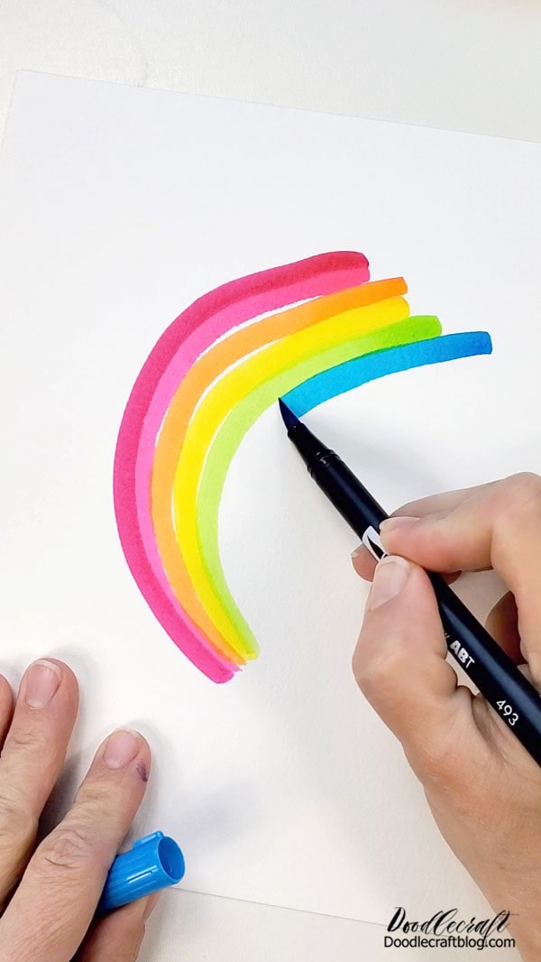 Repeat drawing the curved arches in the rainbow colored markers until completed. Let one end of the rainbow be wide and sporadic and then have them come together on the other side tighter. This gives it the perfect "shooting star" look.