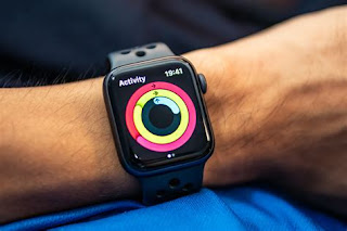 arm met apple-watch waarop een rode ring, daar binnen een gele ring en daar weer binnen een (gedeeltelijk gevulde) blauwe ring