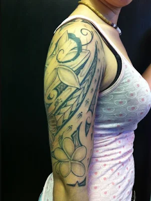 chica con tatuaje maori de flor en el brazo