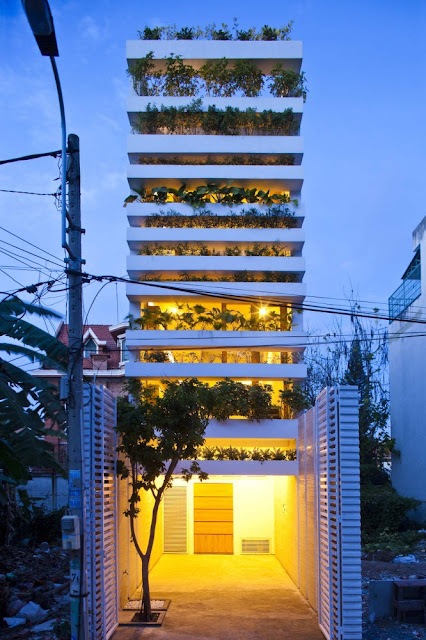 Photo of green home at night with lights turned on