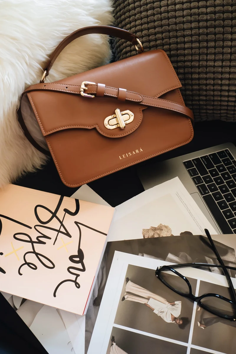 brown leather handbag on a furry white background