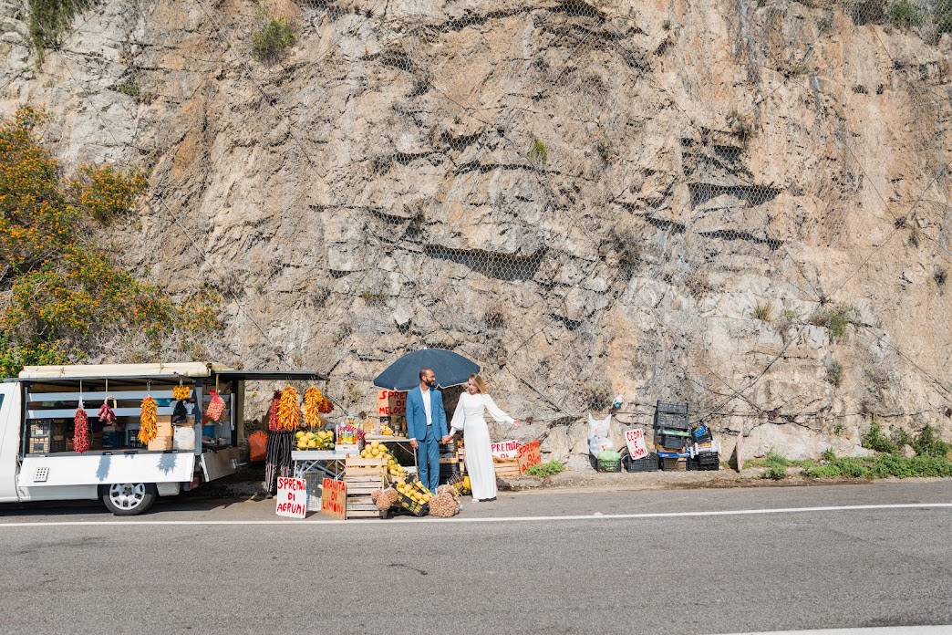 Bride and groom with fruit van on the side of the Amalfi coast road