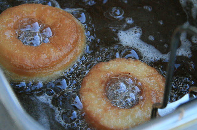 Two cronuts made differently being deep-fried. Top-left: a very dough-nut inflated Pillsbury, bottom-right: Wheel-like Dinner With Julie.