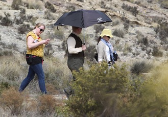 A western-dressed cast member walks to set (middle). Do you recognise him?