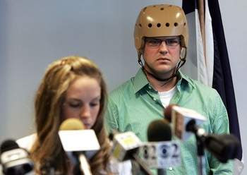 Injured Cedar Rapids Police Officer Tim Davis listens as his wife Stephanie Davis reads a statement regarding Tim's current condition and his prognosis on Thursday, June 4, 2009, during a press conference at the Cedar Rapids Police Department.