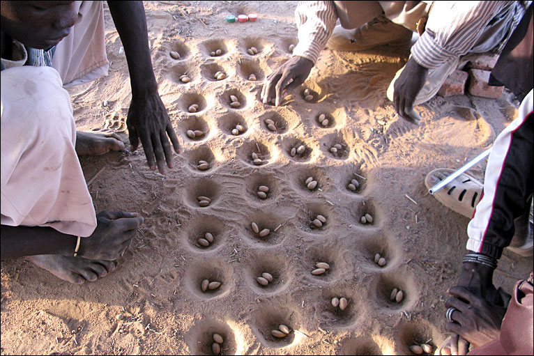 Playing mancala in the sand in the Sudan.