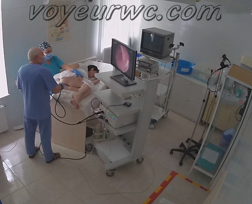 A patient lies on their side while a gastroenterologist inserts a colonoscope (Female colonoscopy SpyCam 25)