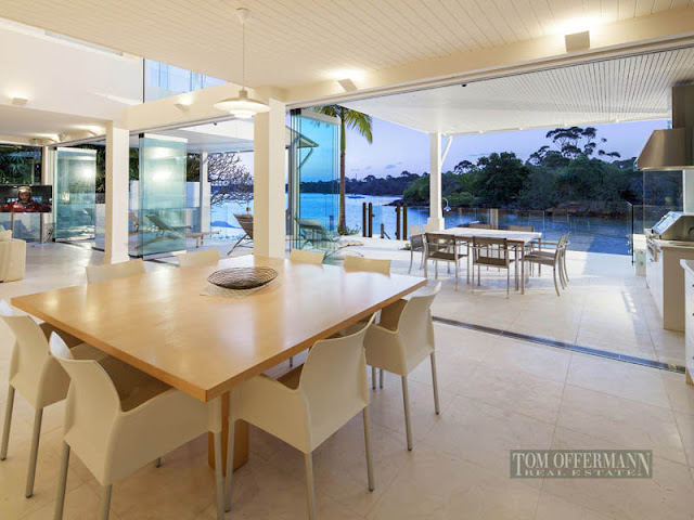 Photo of large open dining room with wooden dining table and modern chairs with the view of water