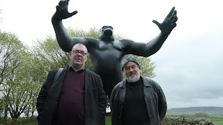Robert Lloyd and Stewart Lee in front of a giant gorilla statue