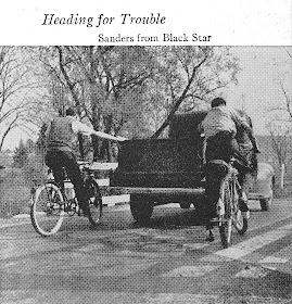 Two boys on bicycles holding onto the back of a truck for a pull