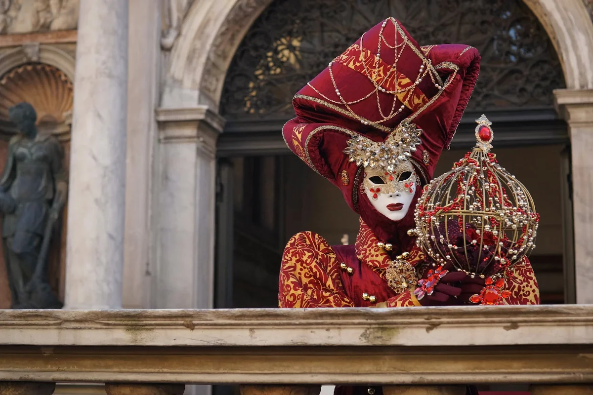 woman on a balcony in a masquerade costume and mask