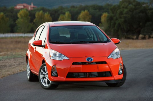 Habanero (Orange) 2012 Toyota Prius C with trees in background