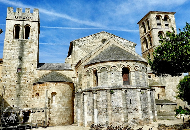 Bâtie dans le style roman occitan, l'abbatiale comporte deux clochers carrés dont  celui placé au sud est fortifié.