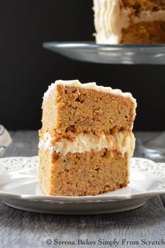 A slice of Carrot Cake with Pineapple Cake with Cream Cheese Frosting on a white plate.