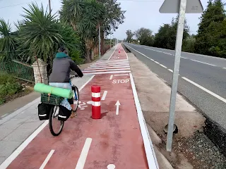 Aim'jie rides on a red bike lane, on the ground is written "STOP".