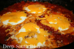 Eggs are dropped into a bed of fiery tomato sauce, made from fresh tomatoes paired with chunky Rotel and enhanced with bacon, onion and sweet bell peppers, and then passed in the oven to set, topped with cheese and served over cheese grits.