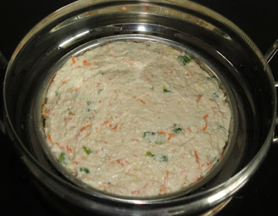 Batter plate put in a steamer to make rava veggie dhokla