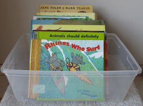 collection of picture books in a plastic bin