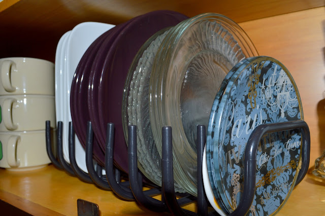 using a dish drainer to hold the dishes up right in a cabinet