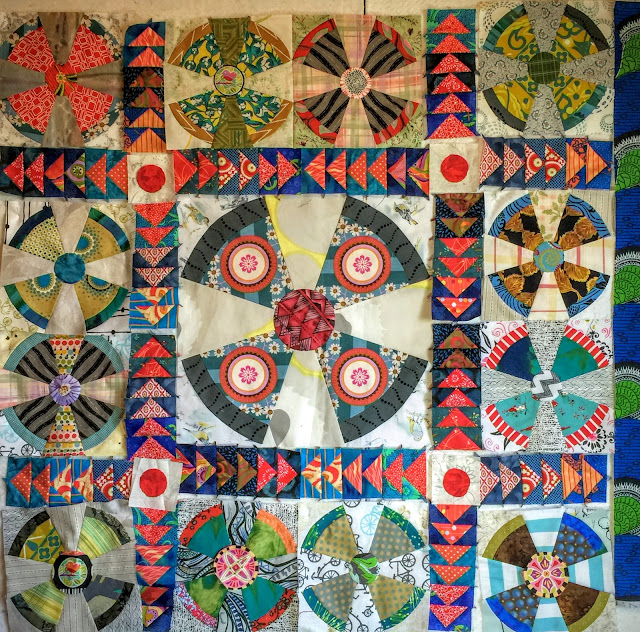 Propeller baby quilt with flying geese sashing and red circle posts