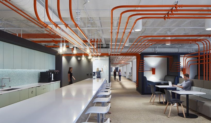 El diseño de esta oficina utiliza tubos de color naranja para guiar a las personas alrededor del espacio