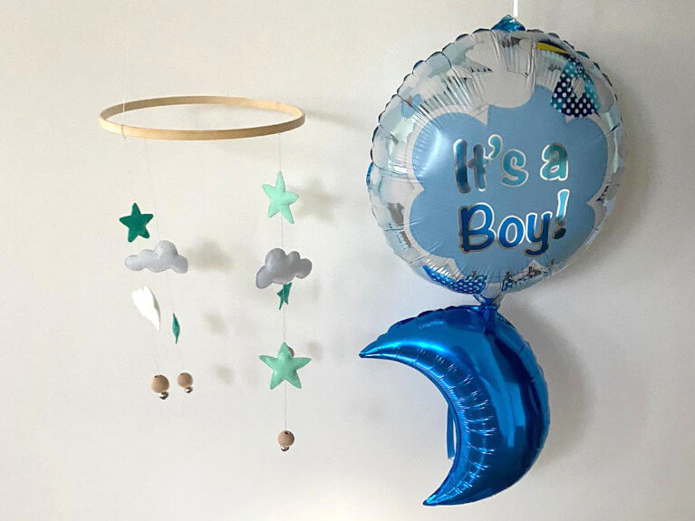 Babyparty Dekoration in blau mit Ballons und Mobile