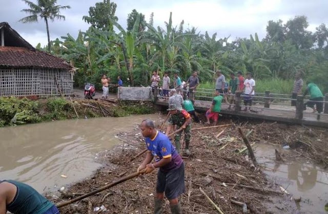 Babinsa Koramil 05 Weru Bantu warga bersihkan sampah yang akibatkan sungai meluap di desa Grogol, Kec. Weru, Kab. Sukoharjo.