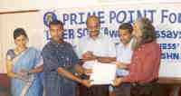 Mr S Vadivelan receiving the first prize for his Tamil essay