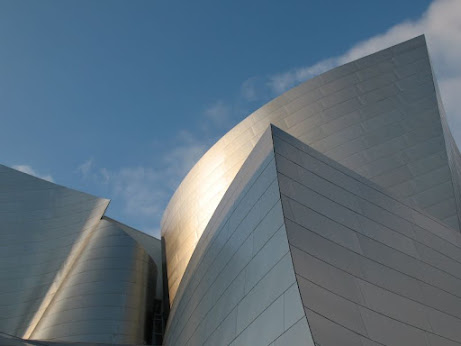 Photo of a complicated set of Walt Disney Concert Hall's angles, depicting intersecting curved and  pointy planes and blue sky.