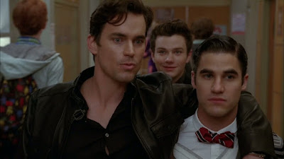 Cooper with his arm around Blaine, Kurt is walking behind them