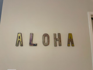 A wall sign that says, "Aloha." Maui luxury real estate