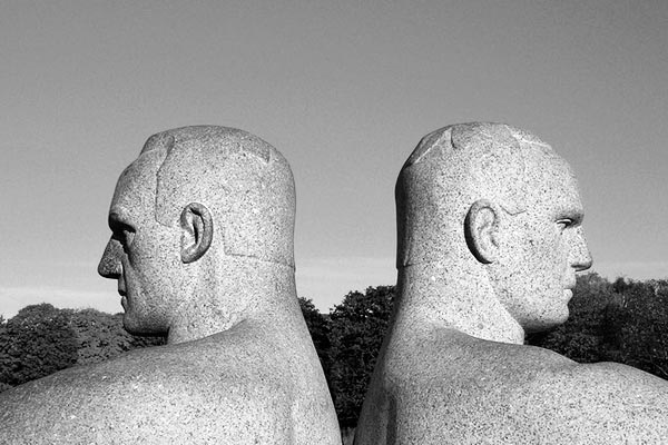 Estatua de dos hombres dándose la espalda.