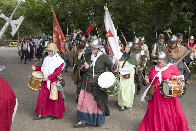 foto de uma recriação do exército anglo-saxão com tambores, bandeiras, vestimentas e capacetes para a guerra