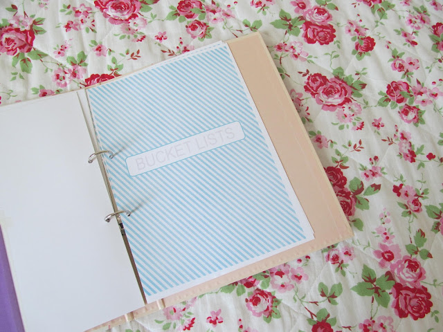 pale peach binder opened on blue striped A4 paper reading 'BUCKET LISTS'