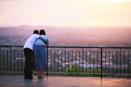 #PraCegoVer: Casal assistindo ao nascer do sol.