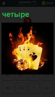 В огне пылают четыре карты разной масти с игральной фишкой для казино, символизирующие проигрыш в игре