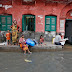 People escape a flooded street after heavy rainfall in Kolkata