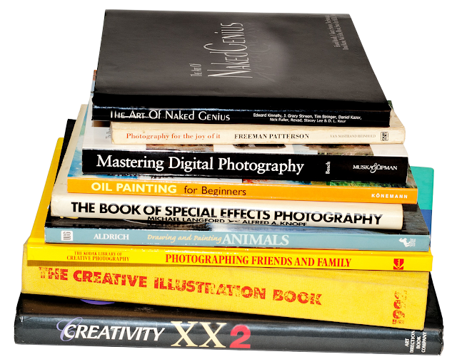 A series of hard cover art and photography books stacked.