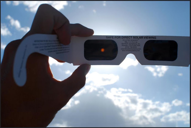 Look directly at the sun through eclipse glasses