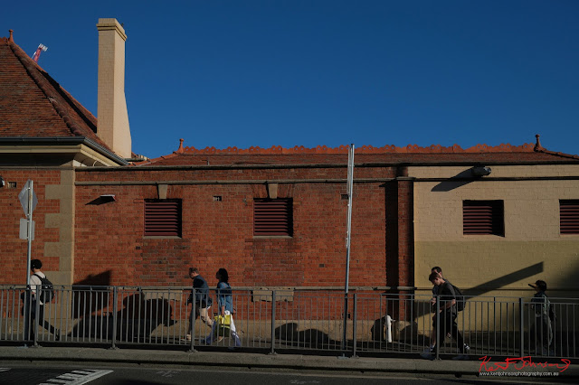 Redfern Station ,Uni Students, and terracotta ridge capping against a blue Australian sky. Fujifilm X100VI in Newtown