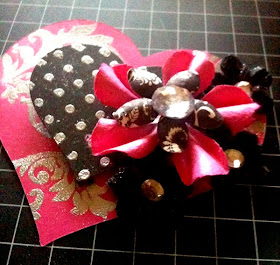 paper piecing heart made with plain pink card stock paper and embossed with silver. Second heart is black card stock embossed with silver polka dots and flowers added.