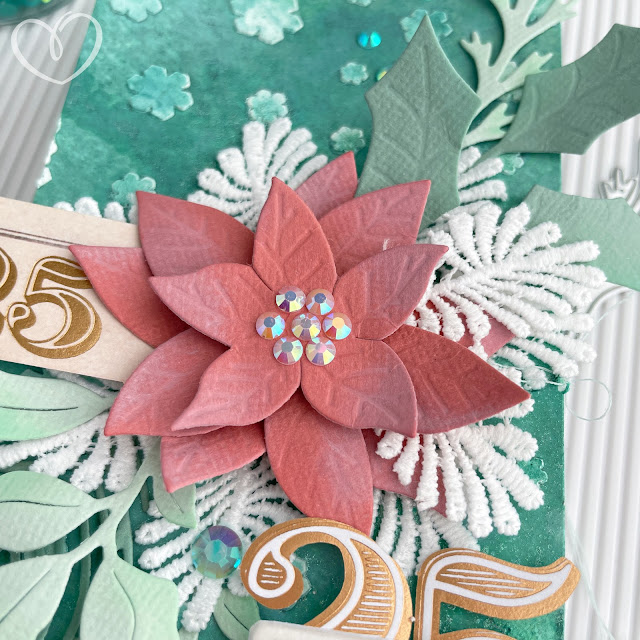 Handmade mixed media Christmas tag with greenery and poinsettia flower made with products from Scrapbook.com, Sizzix, Tim Holtz and Prima Marketing.