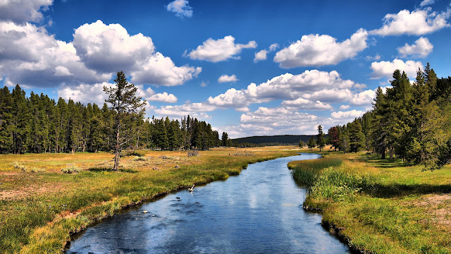 white clouds on blue sky,water and trees on mountain