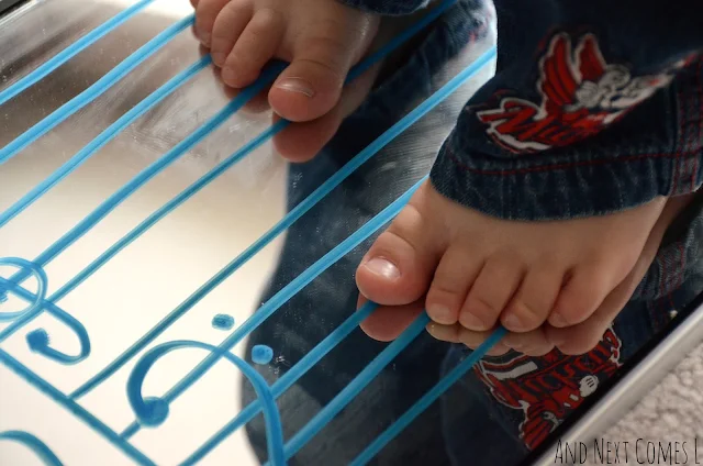 Toddler approach to music theory (aka close up of toddler feet standing on a grand staff drawn on a mirror)