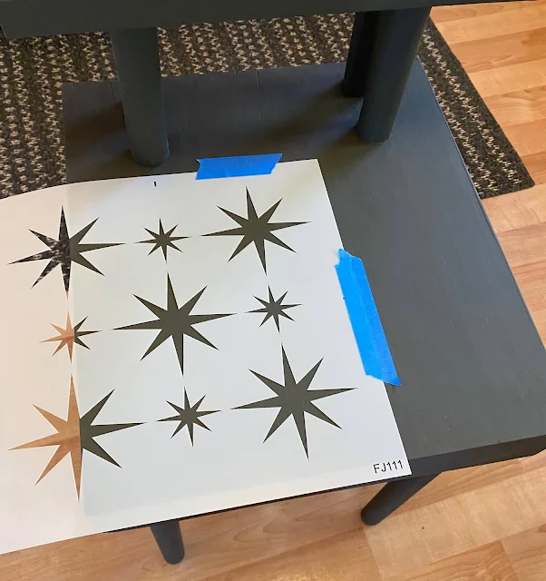 Photo of the Retro Star stencil from Old Sign Stencils being positioned on a table top for stenciling.