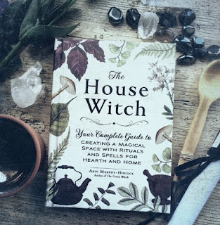 Copy of The House Witch by Arin Murphy-Hiscock surrounded by crystals and flowers