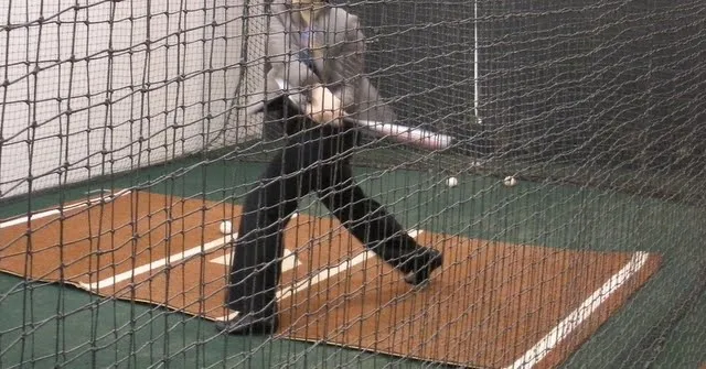 Woman in a suit in a batting cage at Oracle Park